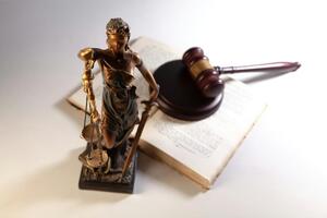Judge's gavel and blindfold statue of justice holding scales
